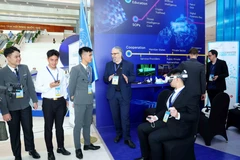 Delegados visitan el espacio de exhibición de tecnología de las Naciones Unidas durante la ceremonia de firma de la Convención de Hanoi. (Foto: VNA)