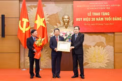 El presidente de la AN, Tran Thanh Man (derecha), entrega la insignia a Vu Hai Ha, miembro del Comité Central del PCV, subsecretario del Comité del Partido en el Parlamento. (Foto: VNA)