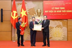 El presidente de la AN, Tran Thanh Man (derecha), entrega la insignia a Vu Hai Ha, miembro del Comité Central del PCV, subsecretario del Comité del Partido en el Parlamento. (Foto: VNA)