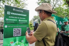 Un hombre escanea el código QR de la plataforma de comercio electrónico VinachemMart (Foto: VNA)