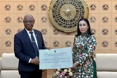 Martin Kabaluapa Kapinga (izq.), jefe de la División de Oficinas Nacionales del WWF, entrega una donación simbólica a Nguyen Thi Anh Thi, vicepresidenta del Comité Popular de Da Nang, para apoyar los esfuerzos de recuperación de la ciudad central tras las fuertes lluvias y el paso del tifón Kalmaegi (Foto: VNA)
