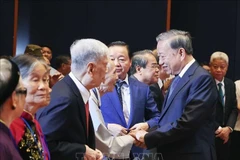 El secretario general del Partido Comunista de Vietnam, To Lam, saluda a las personas con méritos revolucionarios (Foto: VNA)