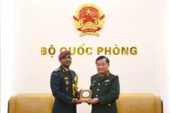 El viceministro de Defensa vietnamita, teniente general Hoang Xuan Chien (derecha), recibe un obsequio del coronel S. Muthukrishnan, agregado de Defensa de la India en Hanoi (Foto: qdnd.vn)