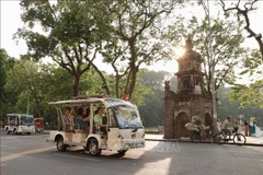 Turistas recorren el lago Hoan Kiem en coches eléctricos. (Foto: VNA)