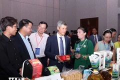 El embajador de Hanoi en Phnom Penh, Nguyen Minh Vu, y empresarios camboyanos visitan el stand vietnamita. (Foto: VNA)
