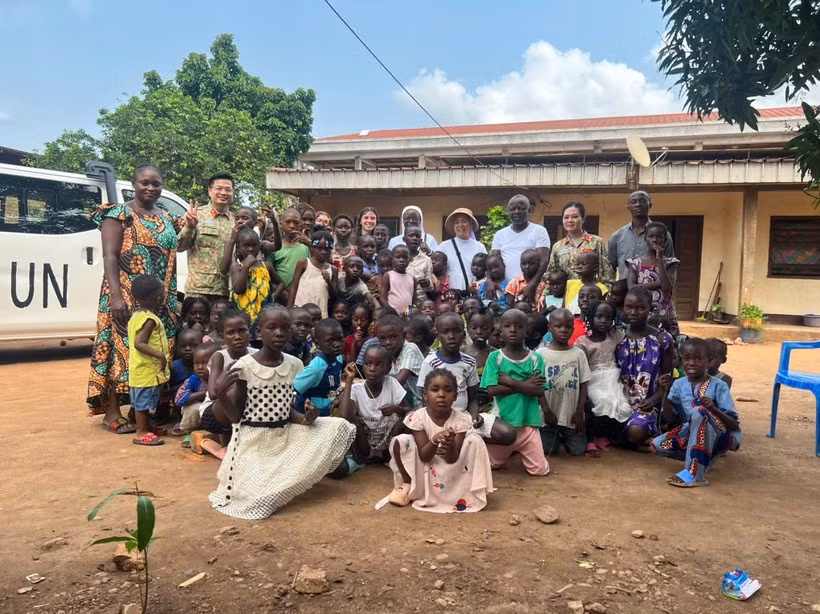 Salim, director del Centro de Apoyo a Niños Huérfanos y Desnutridos de la ciudad de Bimbo (en el centro), junto a los niños, posa para una foto con el destacamento. (Foto: Vietnam+)