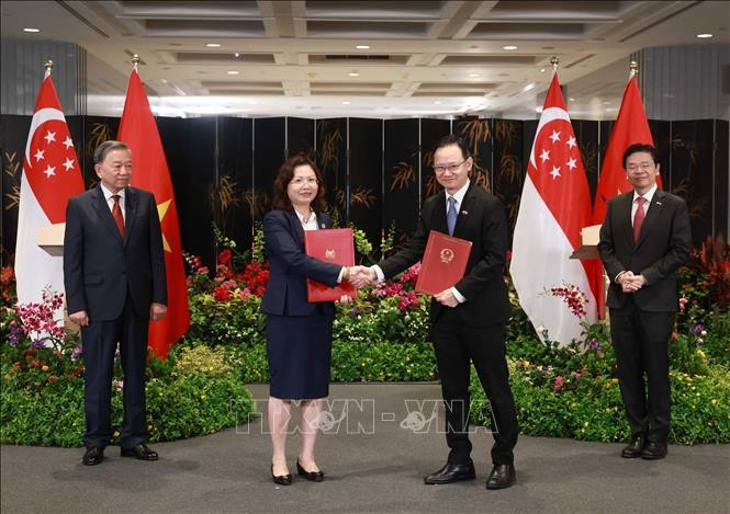 El secretario general del Partido Comunista de Vietnam, To Lam, y el primer ministro de Singapur, Lawrence Wong, presencian el intercambio de la Carta de Intención. (Fuente: VNA)