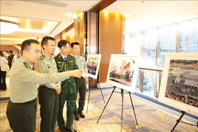 Delegados chinos visitan una exposición fotográfica del desfile militar que celebra el 80 aniversario del Día Nacional de Vietnam. (Fuente: VNA)