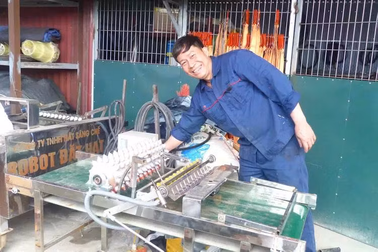 Pham Van Hat, conocido como el “inventor campesino”, y el “robot sembrador”. (Fuente: sggp.org.vn)