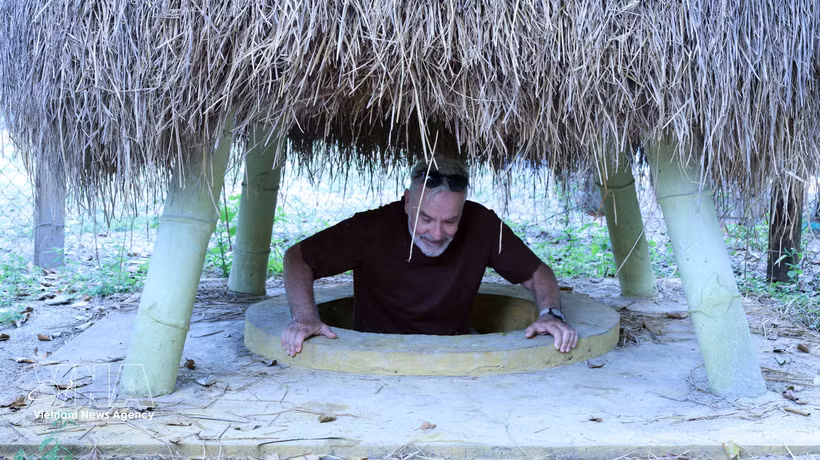 El turista se sitúa en una entrada de túnel ubicada en el jardín de una vivienda en el túnel de Ky Anh. (Fuente: VNA)
