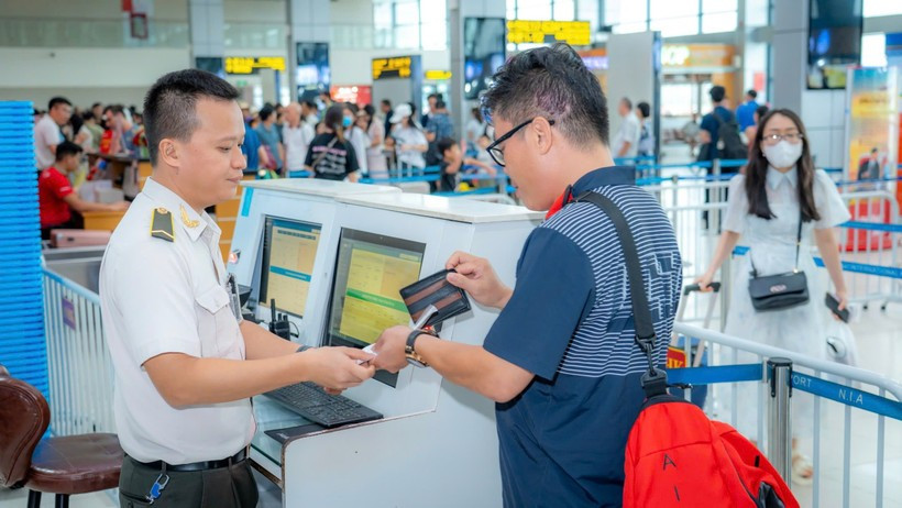 Personal de seguridad aérea verifica los documentos del pasajero antes de abordar el avión. (Fuente: VietnamPlus) 