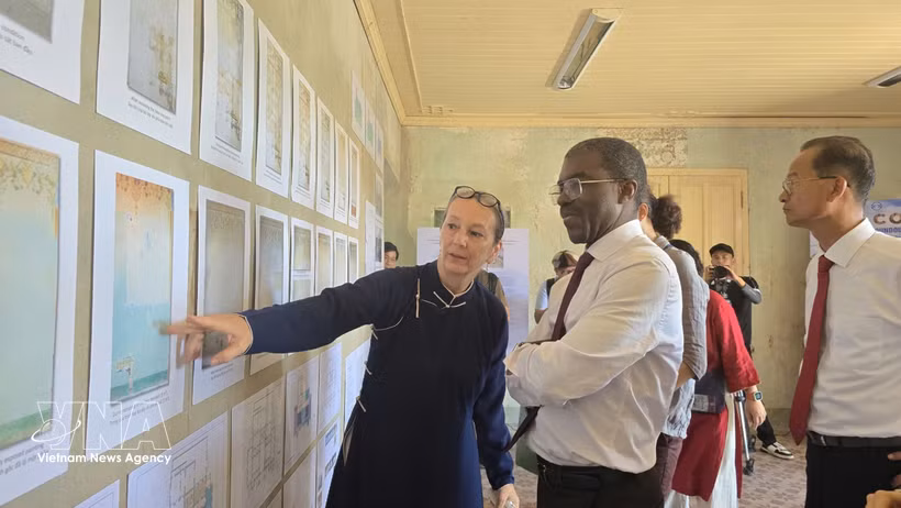 Andrea Teufel, jefa de la representación de la Asociación Alemana para la Conservación del Patrimonio Cultural en Vietnam, presenta el proceso de restauración de murales al director del Centro del Patrimonio Mundial de la UNESCO, Lazare Eloundou. (Fuente: VNA)