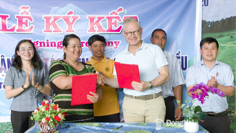 Thi Khui, directora de a Cooperativa Agrícola de Anacardo Orgánico Trang Co Bu Lach, firma un acuerdo de cooperación un representante de la empresa Intersnack Vietnam. (Fuente: Periódico Dong Nai) 