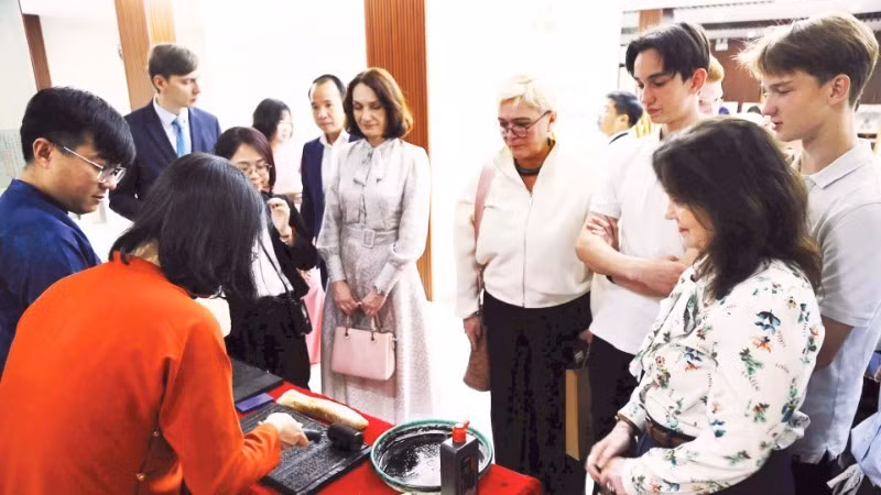 Los turistas extranjeros disfrutan al experimentar la impresión de xilografías. (Fuente: nhandan.vn)
