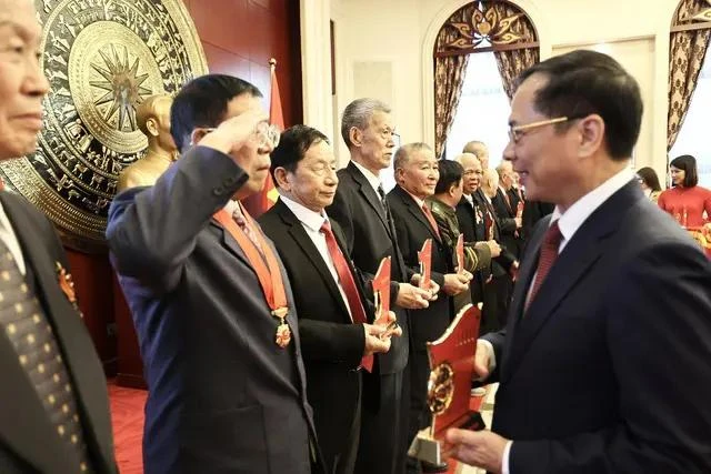 El viceprimer ministro y titular de Relaciones Exteriores, Bui Thanh Son, entrega obsequios a los veteranos chinos (Foto: baochinhphu.vn)