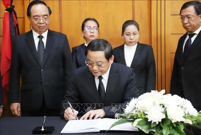 El primer ministro de Laos, Sonexay Siphandone, escribe en el libro de condolencias. (Foto: VNA) 1-5075.jpg.webp