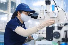 Trabajadores ensamblan componentes ultrapequeños que requieren una alta precisión para la producción de chips semiconductores. Foto: VNA