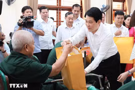El presidente Luong Cuong entrega obsequios a Nguyen Xuan Mai, inválido de guerra, quien recibe tratamiento en el Centro de Rehabilitación de Veteranos de Guerra de Duy Tien. (Foto: VNA)