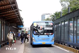Los pasajeros toman un autobús en una estación de la calle Ham Nghi, Ciudad Ho Chi Minh. (Foto: VNA)