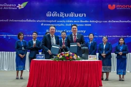 Ceremonia de firma del acuerdo de cooperación para el pago de billetes de avión a través del servicio UNITEL entre Star Fintech y Lao Airlines. (Foto: VNA)