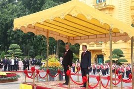 El secretario general To Lam y Díaz-Canel en la tribuna de honor, escuchando las bandas militares interpretar los himnos nacionales de Vietnam y Cuba. Foto: VNA