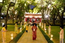 Turistas disfrutan del recorrido nocturno "Sonidos de Vietnam" en el Templo de la Literatura. (Foto: hanoimoi.vn)