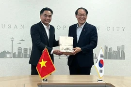 El vicepresidente del Comité Popular municipal, Nguyen Loc Ha, entrega regalos al vicealcalde de la urbe surcoreana de Busan, Lee Jun Seung, (Foto: sggp.org.vn)