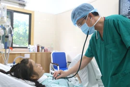 El médico supervisa la salud de la paciente después de la intervención quirúrgica. (Foto: Vietnam+)