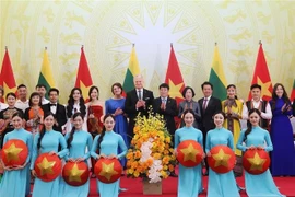 El presidente vietnamita Luong Cuong y su esposa, el presidente lituano Gitanas Nauseda y su esposa, con artistas vietnamitas. (Foto: VNA)