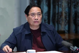 El primer ministro Pham Minh Chinh preside la reunión virtual desde Sudáfrica para dirigir la recuperación tras las consecuencias de las inundaciones. (Foto: VNA)