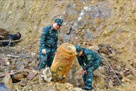 Las autoridades trasladan la bomba al lugar de la detonación. (Foto: VNA)
