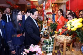 El primer ministro Pham Minh Chinh y su esposa visitan un puesto de productos del Tet en Polonia. (Foto: VNA)