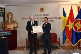 El director de cine sueco Bo Öhlén recibió la insignia “Por la causa de la cultura, el deporte y el turismo”. (Foto: VNA)