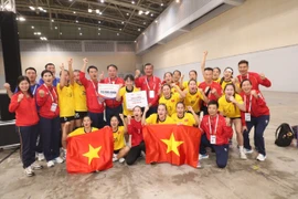Las jugadoras y el cuerpo técnico de la selección femenina vietnamita de balonmano celebran su medalla de oro. (Foto: VNA)