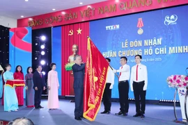 El secretario general del Partido Comunista de Vietnam, To Lam, coloca la Orden Ho Chi Minh en la bandera de la VNA. (Foto: VNA)