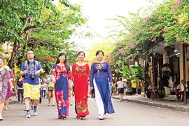 Los turistas visitan el casco antiguo de la ciudad de Hoi An, provincia de Quang Nam. (Foto: nhandan.vn)