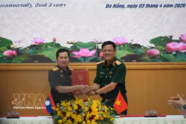 El coronel general Nguyen Truong Thang, viceministro de Defensa de Vietnam, (derecha) y su homólogo laosiano, coronel general Saichay Kommasith, intercambian el acta de diálogo. (Foto: VNA)
