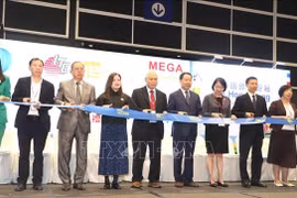 Los delegados cortaron la cinta inaugural de la exposición. (Foto: VNA)