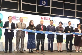 Los delegados cortaron la cinta inaugural de la exposición. (Foto: VNA)
