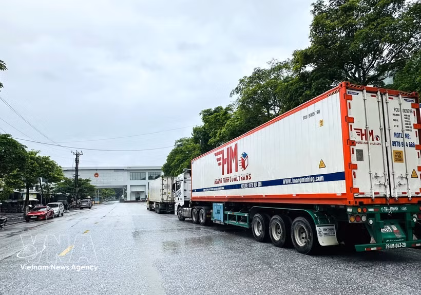 Un convoy de camiones portacontenedores que transportan mercancías realizan los trámites aduaneros en el puesto fronterizo internacional de Thanh Thuy (Tuyen Quang). Foto: VNA
