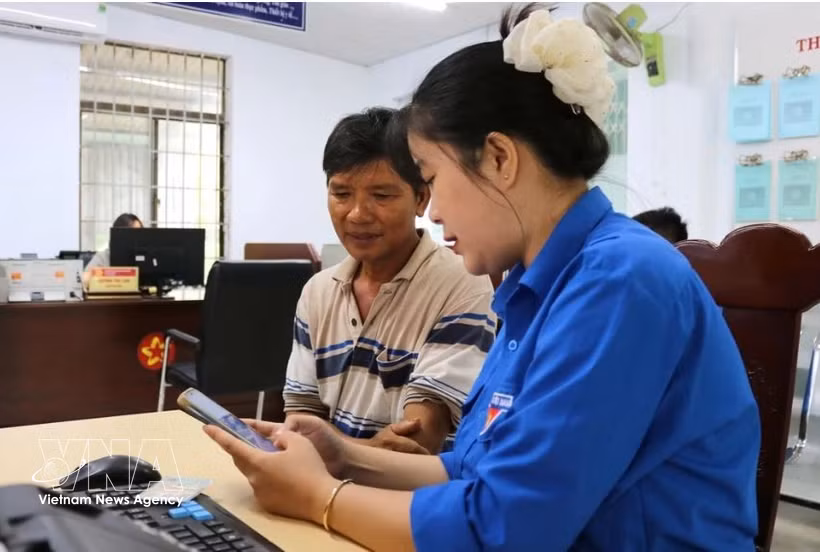 Una jóven de la Unión de Jóvenes Comunistas Ho Chi Minh de la comuna de Tuy An Nam, provincia de Dak Lak, orienta a los residentes sobre cómo completar la información correctamente antes de presentar los documentos para trámites administrativos. Foto: VNA