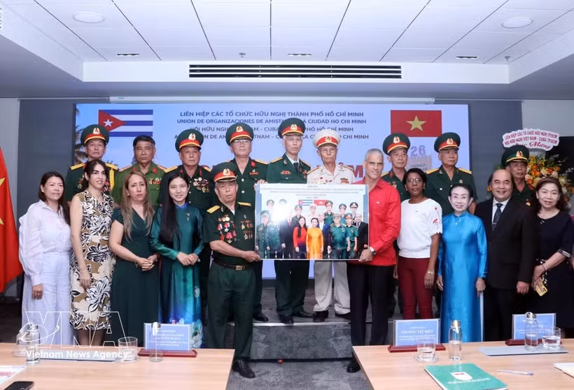 Representantes del comité de enlace de veteranos del Batallón 261 - Giron en Ciudad Ho Chi Minh presentan una foto conmemorativa a Mauricio Alejandro Martínez Duque, Cónsul General de Cuba en la ciudad. (Foto: VNA)