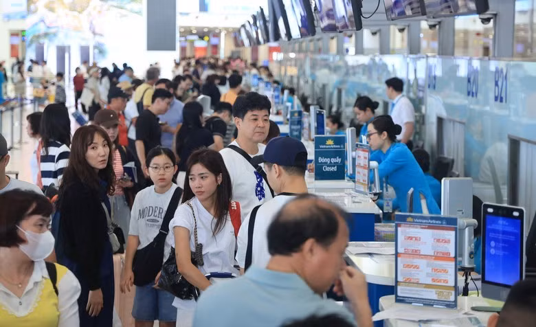 Los pasajeros realizan el check-in en el Aeropuerto Internacional Noi Bai. (Foto: dangcongsan.org.vn)
