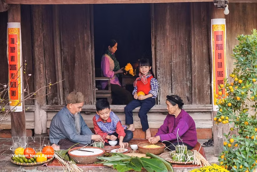 Los miembros de la familia se reúnen para preparar banh chung, un elemento indispensable de la celebración del Año Nuevo Lunar (Tet). (Foto: VNA)