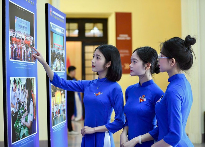 Los delegados visitan la exposición fotográfica sobre las actividades de intercambio y cooperación entre los comités centrales de las uniones de jóvenes de ambos países y la juventud de Vietnam y China a lo largo de los años. (Fuente: Vietnam+) trien-lam-viet-trung.jpg