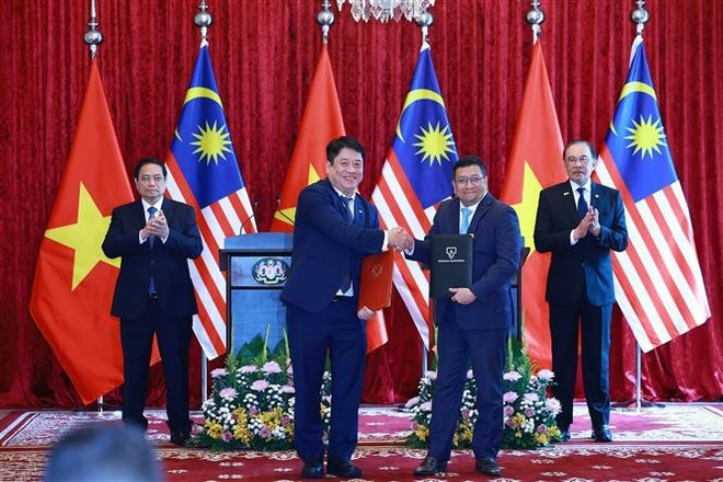 Los dos mandatarios presencian la firma del memorando de entendimiento entre las compañías eléctricas nacionales de ambos países. (Fuente. VNA) vna-potal-thu-tuong-pham-minh-chinh-hoi-dam-voi-thu-tuong-malaysia-anwar-ibrahim-8053379.jpg