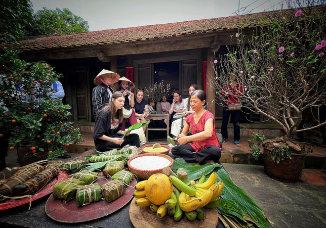Los turistas internacionales aprenden a elaborar banh chung (pastel cuadrado de arroz glutinoso) en una casa antigua de Hanoi (Fuente: Vietnam+) tet-lang-viet-20.jpg