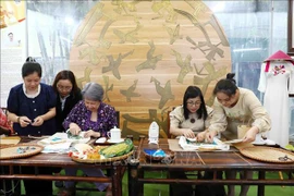 Cónyuges de premieres vietnamita y singapurense visitan taller de artesanía para discapacitados