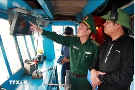 Un oficial de la guardia fronteriza revisa los dispositivos de vigilancia en un barco pesquero (Foto: VNA)