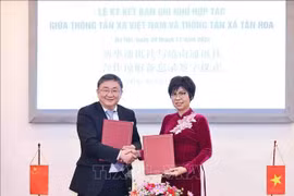 La directora general de la VNA, Vu Viet Trang, y el editor en jefe adjunto de Xinhua, Ren Weidong, firman un memorando de entendimiento sobre los planes de cooperación en 2025 (Foto: VNA)